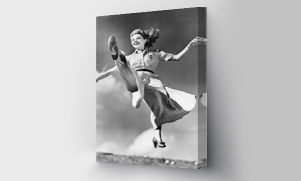 Kobieta w lejącej się sukni skacząca w powietrzu