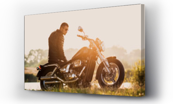 młody brutalny mężczyzna w czarnej kurtce i okularach stojący przy motocyklu