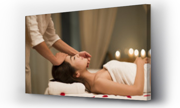 Masażystka wykonuje masaż twarzy kobiecie w spa