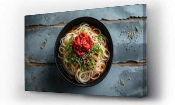 Wizualizacja Obrazu : #1355994638 Bashu cold noodles topped with chili paste, spring onion, and sesame seeds served in a bowl isolated on a wooden table, showcasing a side view of fast food.