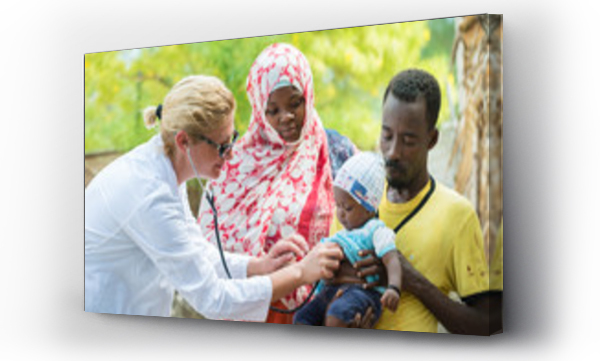 Kobieta lekarz kaukaski słuchania oddech i bicie serca małego afrykańskiego dziecka z stetoskopem.Ojciec trzymając dziecko, matka patrząc na dziecko