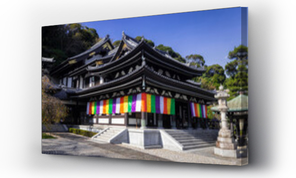 Wizualizacja Obrazu : #1571576138 View of a traditional Japanese temple adorned with vibrant rainbow banners under a clear sky, a serene scene that blends history and culture, Kamakura, Kanagawa, Japan.