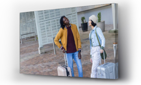 Wizualizacja Obrazu : #1680862283 Diverse friends standing on brick plaza near metal shelter conversing, with rolling suitcases
