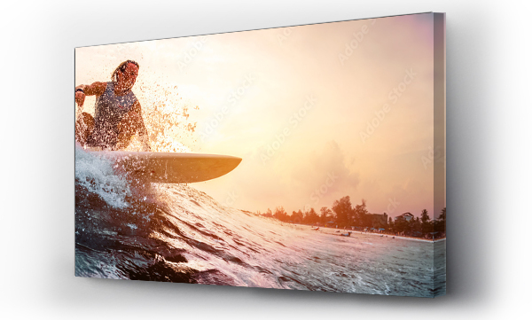 Surfer jeździ na fali oceanu podczas zachodu słońca. Koncepcja sportu ekstremalnego i aktywnego stylu życia