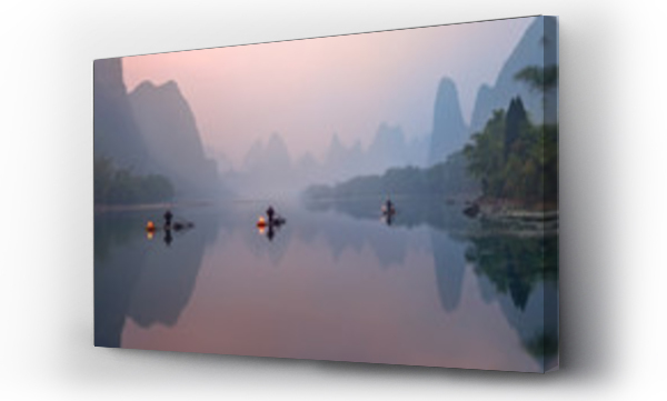 Rzeka Li, Xingping, Chiny, malowniczy krajobraz. Rybacy kormoranów na starożytnych łodziach bambusowych z zapalonymi lampami o wschodzie słońca.