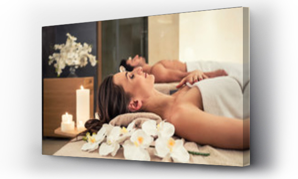 Młody mężczyzna relaksujący się z partnerką na łóżkach do masażu w nowoczesnym centrum spa i wellness