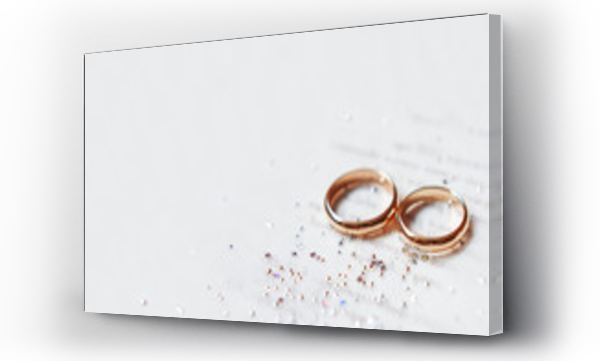 Wizualizacja Obrazu : #212748591 Złote obrączki ślubne na papierowym zaproszeniu z błyszczącymi dżetami. Szczegóły ślubu, symbol miłości i małżeństwa.