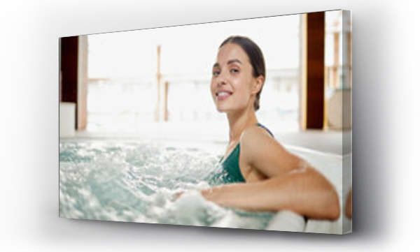 Wizualizacja Obrazu : #216614496 Young woman relaxing in soft waving water while sitting in jacuzzi bath at spa center