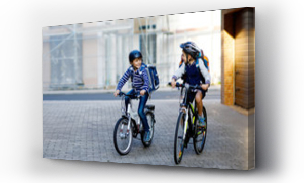 Wizualizacja Obrazu : #219944315 Two school kid boys in safety helmet riding with bike in the city with backpacks. Happy children in colorful clothes biking on bicycles on way to school. Safe way for kids outdoors to school