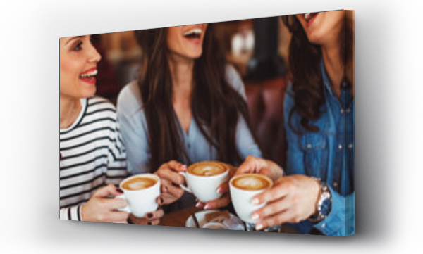 Trzy młode kobiety piją kawę w kawiarni