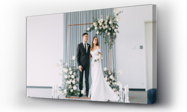 Wizualizacja Obrazu : #227267878 Stylowa europejska ceremonia ślubna. Para młoda otoczona przez gości. Łuk i dekoracja z świeżych kwiatów. Pomysły na wesele