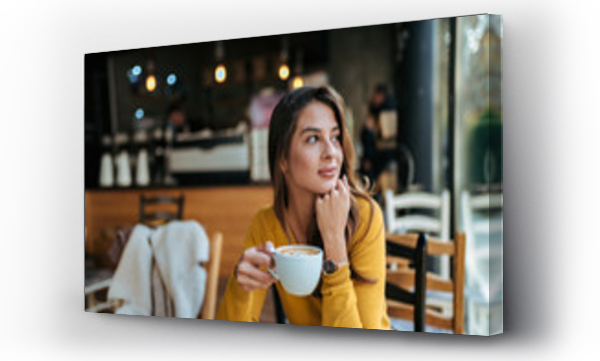 Wizualizacja Obrazu : #234283412 Stylowa młoda kobieta pijąca kawę w kawiarni, patrząca w dal.