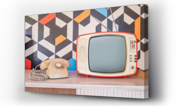 Wizualizacja Obrazu : #240460586 Retro telewizor z zabytkowym telefonem i tapetą w tle. Szablonowa dekoracja wnętrza z ceramicznymi dekoracjami z lat 70.