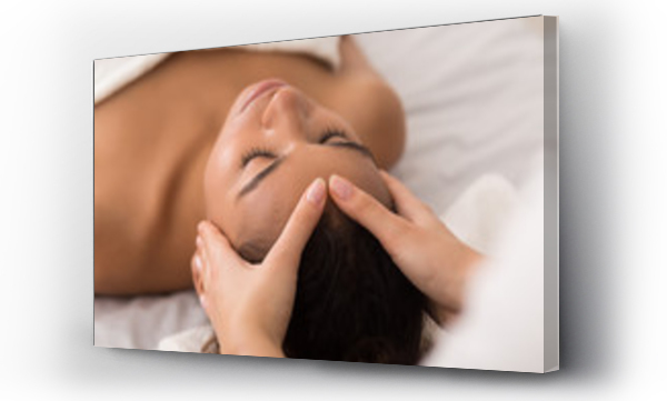 Kobieta korzystająca z przeciwstarzeniowego masażu twarzy w salonie spa