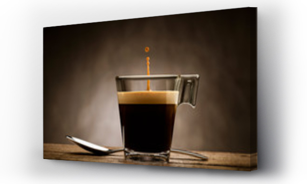 Wizualizacja Obrazu : #246957246 Black coffee in glass cup with teaspoon and jumping drop, on wooden table