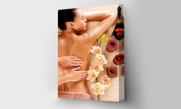 Masażysta wykonujący masaż pleców kobiety w salonie spa