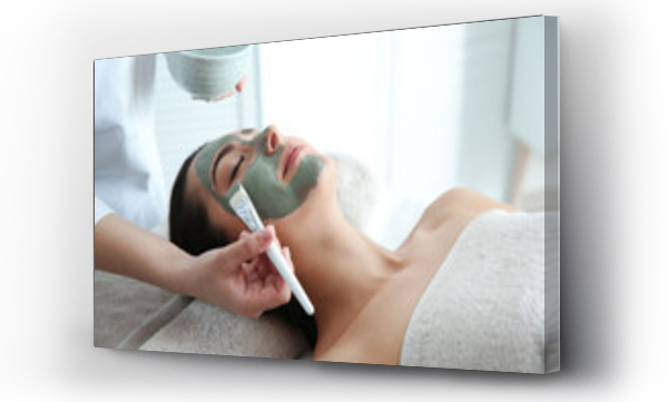 Kosmetolog nakładający maseczkę na twarz klienta w salonie spa