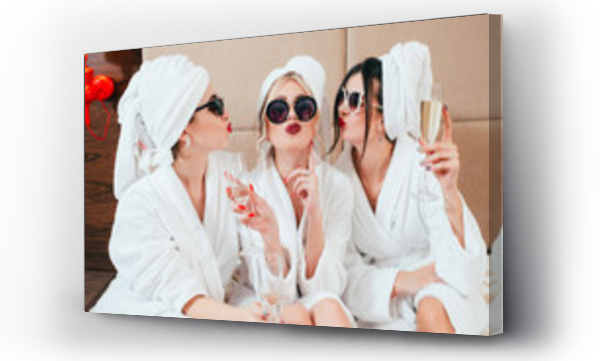 Uroczyste przyjęcie w spa. Przyjaciele gratulacje. Młode kobiety z szampanem. Okulary przeciwsłoneczne, szlafroki i turbany na sobie.