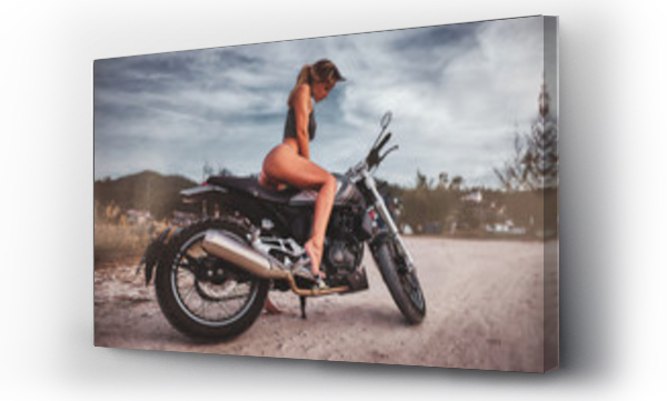Portret młodej seksownej kobiety w bikini siedzącej na zabytkowym motocyklu