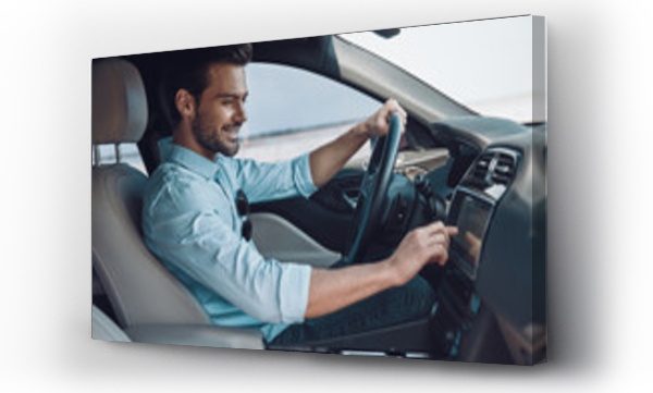 Wizualizacja Obrazu : #266334979 Enjoying his drive. Handsome young man in smart casual wear smiling while driving a status car