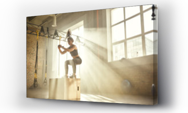 Trening. Widok z boku pięknej wysportowanej kobiety w stroju sportowym trenującej nogi na siłowni.