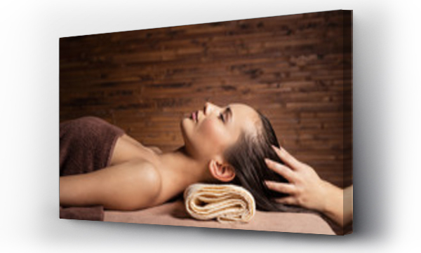 Masażysta wykonujący masaż głowy i włosów dla kobiety w salonie spa