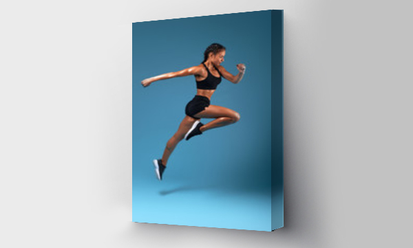 Wizualizacja Obrazu : #297123508 profesjonalny sportowiec trening w centrum sportowym, pełna długość side view photo. odizolowane niebieskie tło, ujęcie studyjne.zdrowie i pielęgnacja ciała, wellness, kobieta biegnie do swojego marzenia