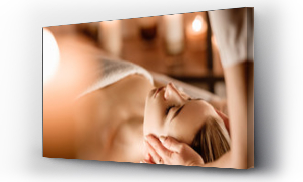 Wizualizacja Obrazu : #299581611 Beauty and youth. Hands of the masseuse make massage for a beautiful charming woman lying in a spa salon on a massage table.Traditional oriental massage therapy and beauty treatments.