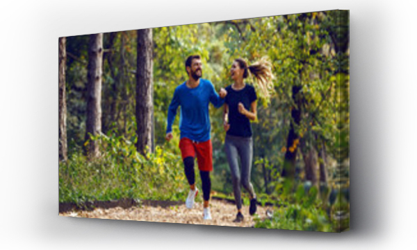 Wizualizacja Obrazu : #300360735 Pełna długość fit sportowy szczęśliwy caucasian para w strojach sportowych bieganie w lesie na szlaku w godzinach porannych.