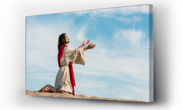 jezus modlący się na kolanach na piasku na pustyni na tle nieba