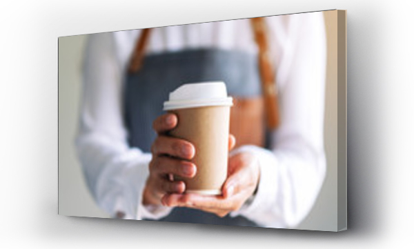 Kelnerka trzymająca i podająca papierowy kubek z gorącą kawą w kawiarni