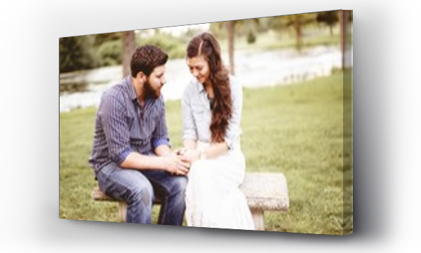 Wizualizacja Obrazu : #305850280 Beautiful shot of a happy couple holding hands while praying with a blurred background