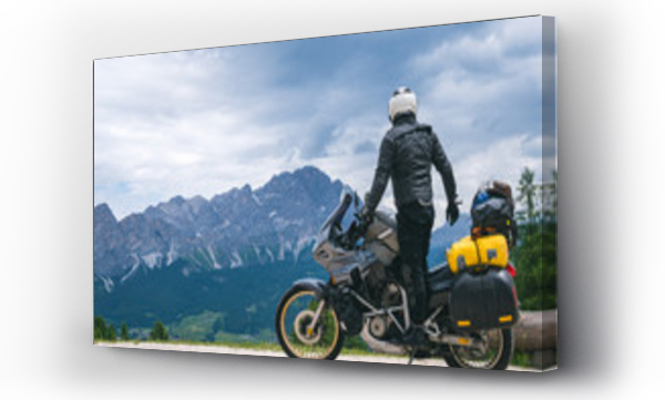 Widok z tyłu stylowy motocyklista na motocyklu turystycznym przygody w pełnym wyposażeniu na drodze gruntowej, Spójrz na odległość na szczycie gór Dolomitów, koncepcja podróży, kopiowanie przestrzeni. Cortina Ampezzo, Włochy