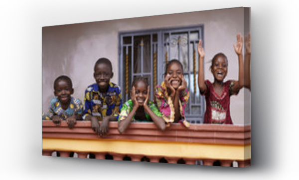 Pięcioro afrykańskich dzieci pozdrawiających bajpasów z balkonu kolonialnego domu