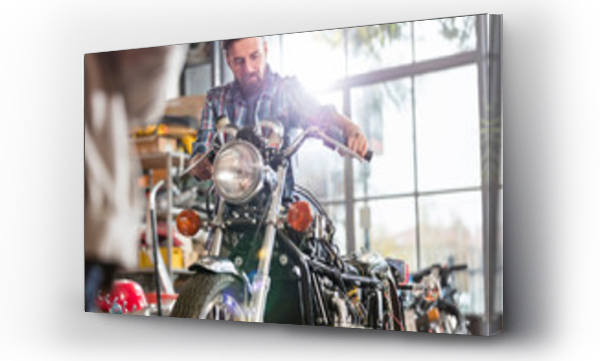 Wizualizacja Obrazu : #315206330 Male motorcycle mechanic working on motorcycle in workshop