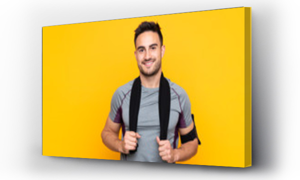 Wizualizacja Obrazu : #316404290 Sport man over isolated yellow wall with sport towel