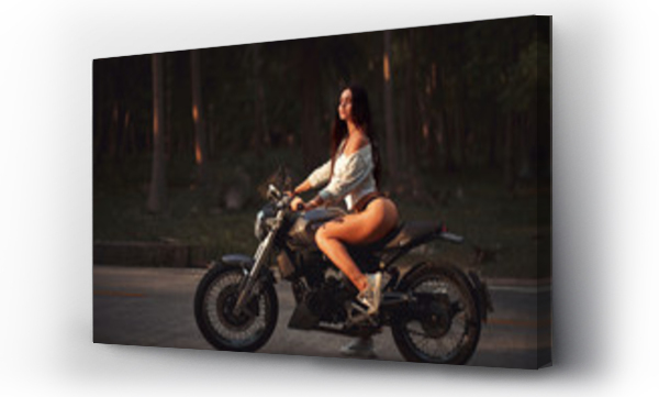 Seksowna wysportowana kobieta z czarnym motocyklem w stylu cafe racer