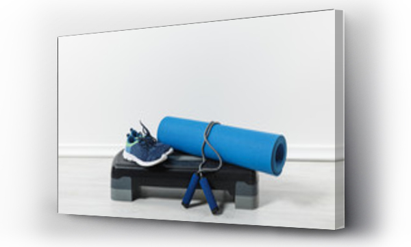 Wizualizacja Obrazu : #325749511 step platform, fitness mat, jump rope and sport shoes on floor at home