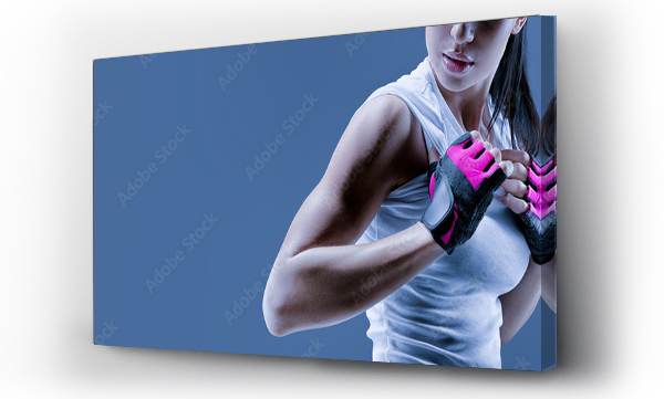 Wizualizacja Obrazu : #361681524 Koncepcyjny portret z bliska fitness atletycznej młodej modelki w odzieży sportowej. Pewna siebie kobieta kulturystka z siłową ręką w rękawiczkach na stonowanym niebieskim tle
