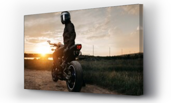 Wizualizacja Obrazu : #369118663 Back view of biker sitting on motorcycle in sunset on the country road.
