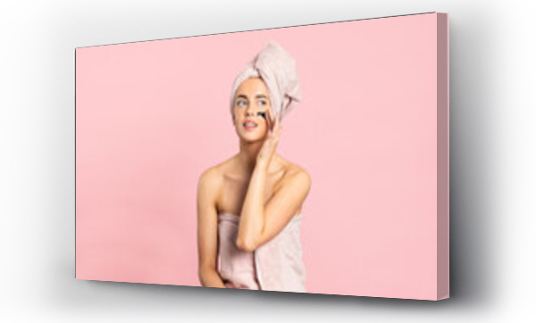 Wizualizacja Obrazu : #380744627 Young woman applying charcoal mask on face enjoying spa day while standing looking away on pink background