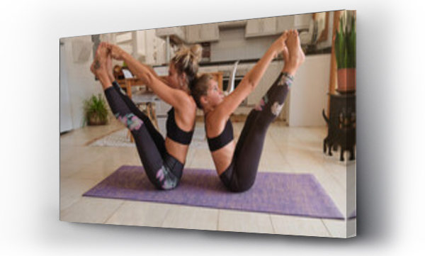 Wizualizacja Obrazu : #380746874 Blonde mother and daughter wearing the same sport clothes sitting on a mat on the kitchen floor practicing yoga with their backs together