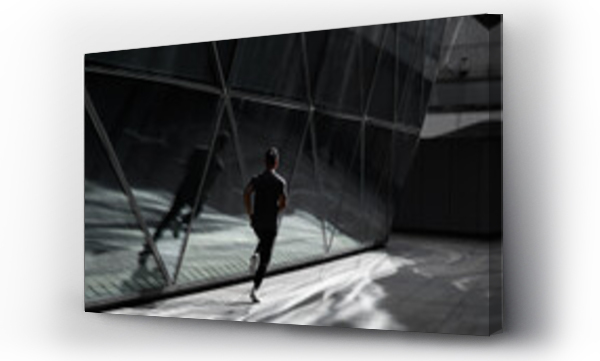Wizualizacja Obrazu : #382256342 Male runner runs in city beside a glass architecture