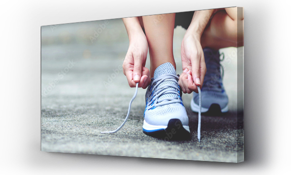 Wizualizacja Obrazu : #387083850 Running shoes. close up female athlete tying laces for jogging on road. Runner ties getting ready for training. Sport lifestyle. copy space banner.
