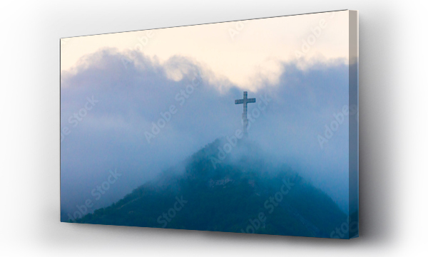 Wizualizacja Obrazu : #409204237 A single cross stands on a mountain engulfed in white clouds