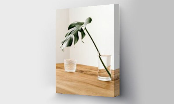 Wizualizacja Obrazu : #409959755 Minimalist interior with monstera stem arranged in vase with water near glass cup on wooden table