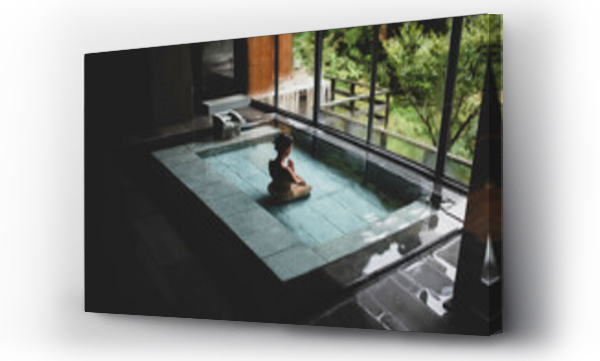 Wizualizacja Obrazu : #409978809 Young caucasian woman kneeling inside a thermal waters bath and meditating with hands in prayer at a traditional Japanese onsen