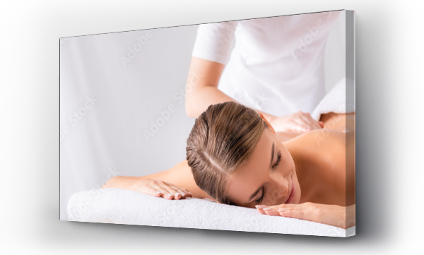 masażysta masujący zadowoloną młodą kobietę na stole do masażu w salonie spa, baner