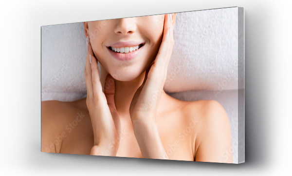 Wizualizacja Obrazu : #410386717 Top view of happy woman touching cheeks and lying on massage table in spa salon, banner