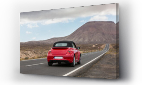 Wizualizacja Obrazu : #413846634 Bordeaux samochód jadący po pustej, utwardzonej drodze w pustynnym, wulkanicznym krajobrazie